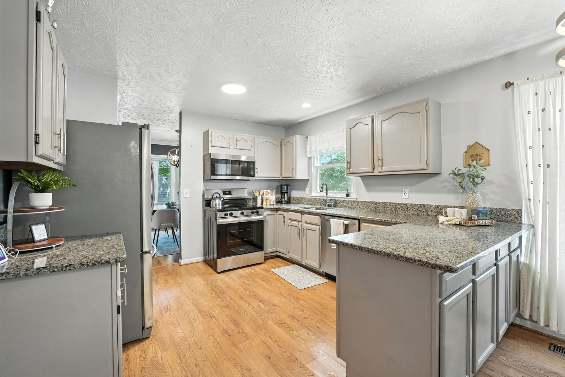 Updated kitchen with granite counters, white cabinetry, and styled island
